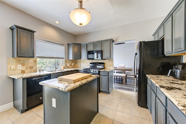 kitchen featuring sink, hanging light fixtures, a center island, light tile patterned floors, and black appliances