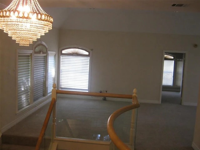 carpeted spare room with a notable chandelier