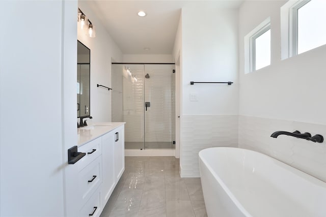 bathroom with tile patterned floors, vanity, shower with separate bathtub, and tile walls