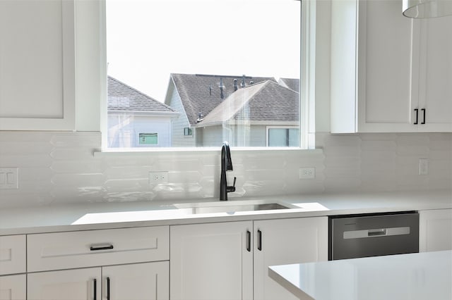 kitchen featuring white cabinetry, sink, decorative backsplash, and stainless steel dishwasher