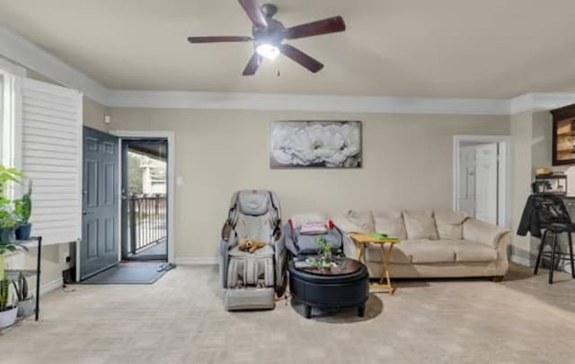 carpeted living room with a ceiling fan, baseboards, and ornamental molding