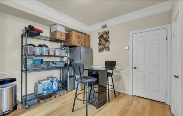 interior space with visible vents, crown molding, and wood finished floors