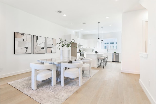 dining space with light wood-style floors, visible vents, and recessed lighting