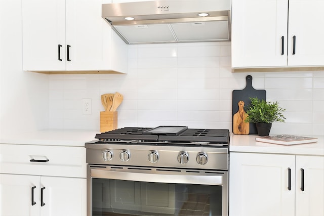 kitchen featuring light countertops, stainless steel gas range, exhaust hood, and white cabinets