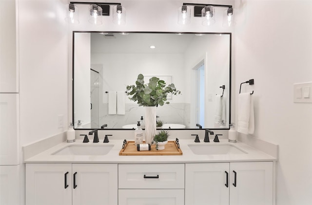 bathroom with a sink, a shower stall, and double vanity