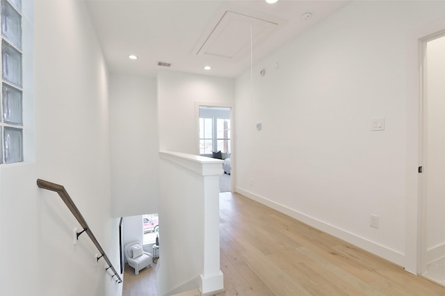 hall featuring attic access, baseboards, light wood-style flooring, an upstairs landing, and recessed lighting