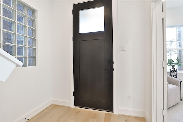 foyer entrance with light wood-type flooring and baseboards