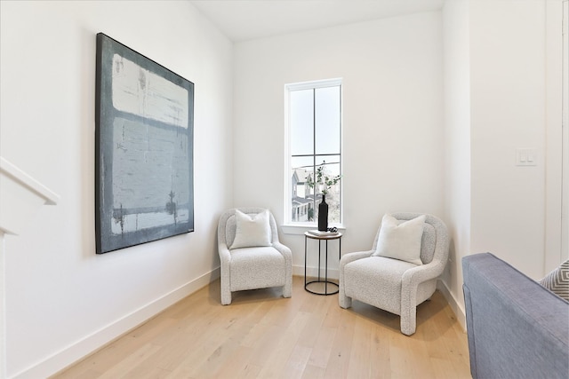 sitting room featuring baseboards and light wood finished floors