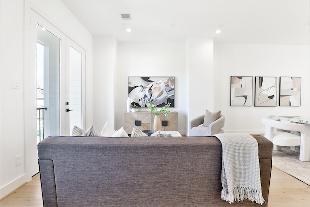 living area featuring baseboards, recessed lighting, visible vents, and light wood-style floors