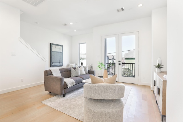 living area with light wood-type flooring, baseboards, and recessed lighting