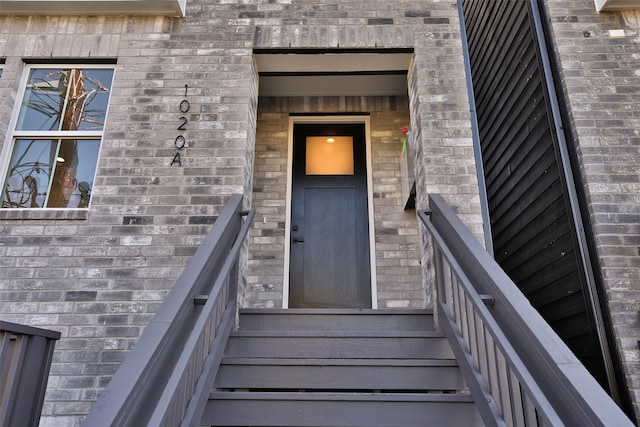 entrance to property featuring brick siding