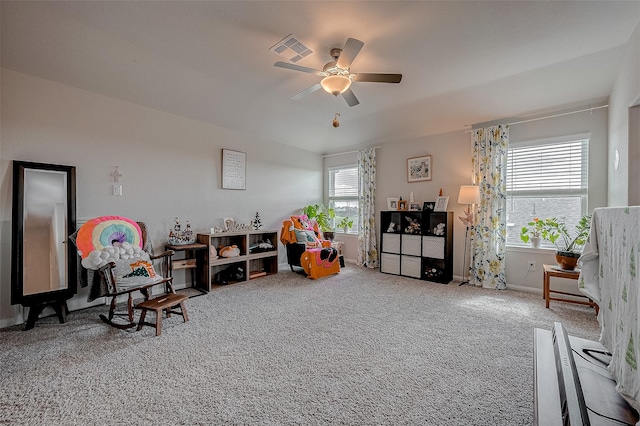 living area featuring ceiling fan and carpet