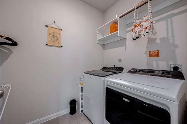 clothes washing area featuring light tile patterned flooring and washer and clothes dryer