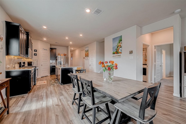 dining space featuring sink and light hardwood / wood-style flooring