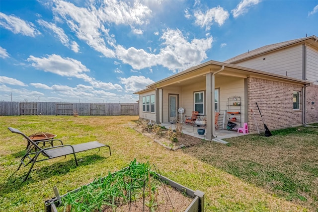 rear view of property featuring a yard and a patio