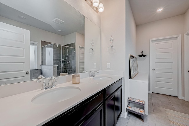 bathroom with a shower with door, vanity, and tile patterned flooring