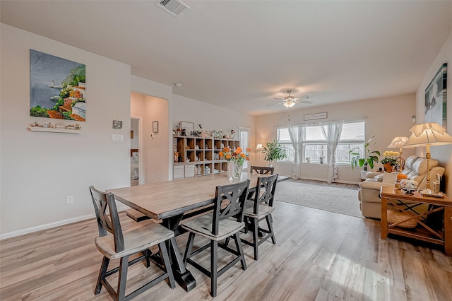 dining space with ceiling fan and light wood-type flooring