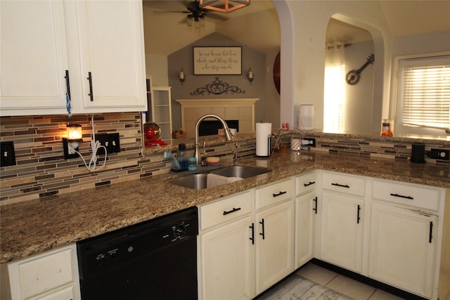 kitchen with stone countertops, black dishwasher, sink, and kitchen peninsula