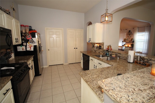 kitchen with sink, hanging light fixtures, light stone counters, black appliances, and white cabinets