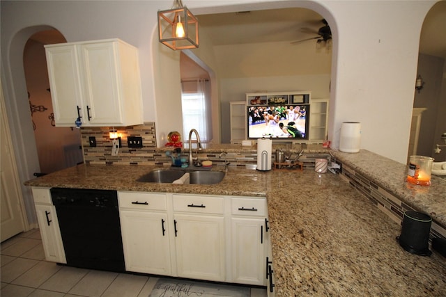 kitchen with pendant lighting, black dishwasher, sink, and light stone countertops