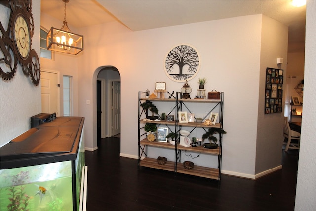 corridor featuring dark hardwood / wood-style floors and a chandelier