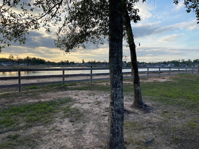 yard at dusk with a water view and a rural view