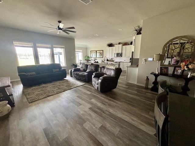 living room with dark wood-type flooring and ceiling fan