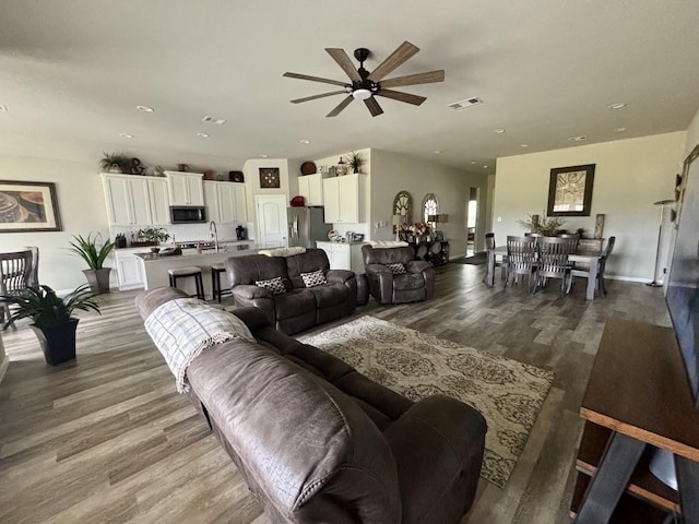 living room with hardwood / wood-style flooring and sink