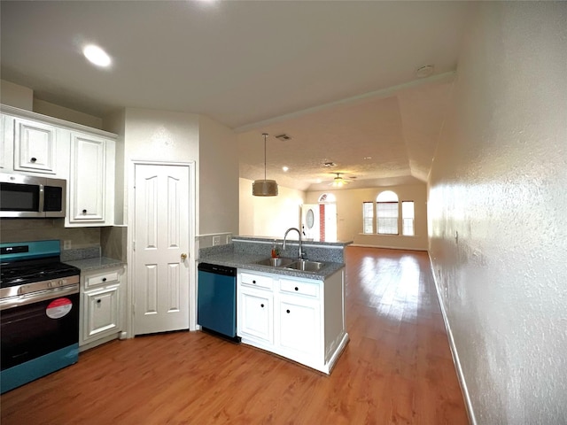 kitchen with stainless steel appliances, sink, hardwood / wood-style floors, and white cabinets