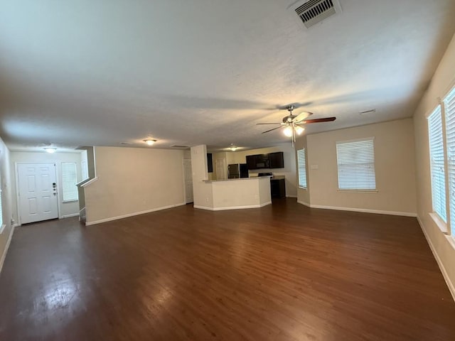 unfurnished living room featuring ceiling fan and dark hardwood / wood-style floors