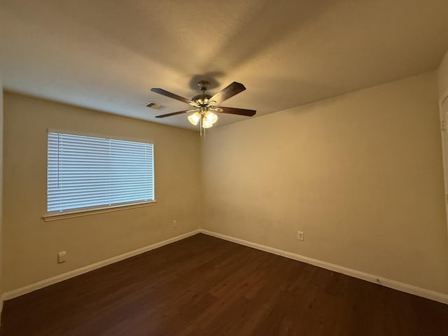 unfurnished room featuring dark wood-type flooring and ceiling fan