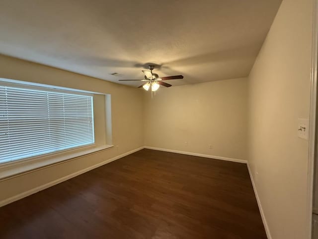 unfurnished room with ceiling fan and dark hardwood / wood-style flooring