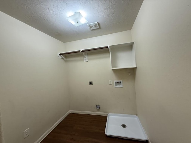 washroom featuring electric dryer hookup, hookup for a washing machine, dark wood-type flooring, and a textured ceiling