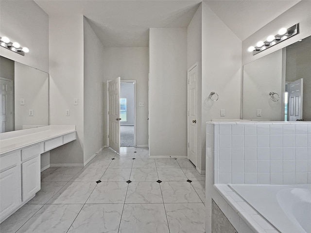 bathroom featuring vanity and tiled bath