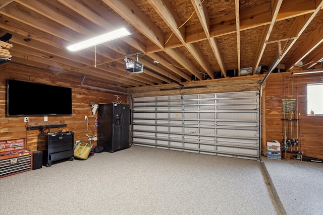 garage featuring a garage door opener and wood walls