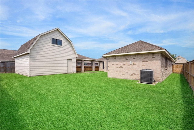 back of house featuring a yard and central AC unit