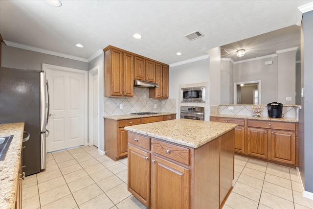 kitchen featuring light tile patterned floors, crown molding, appliances with stainless steel finishes, light stone counters, and a kitchen island