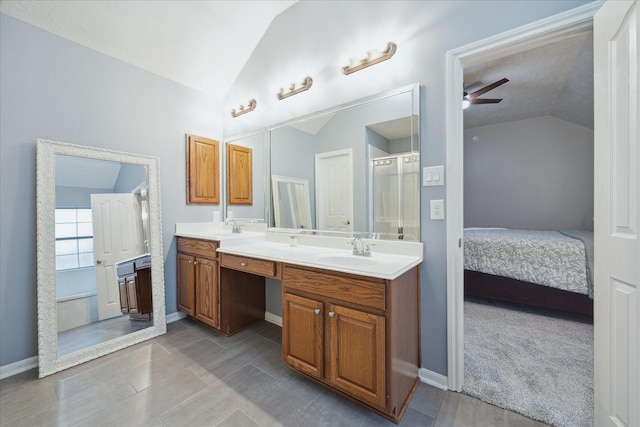 bathroom with vanity, vaulted ceiling, a shower with shower door, and ceiling fan