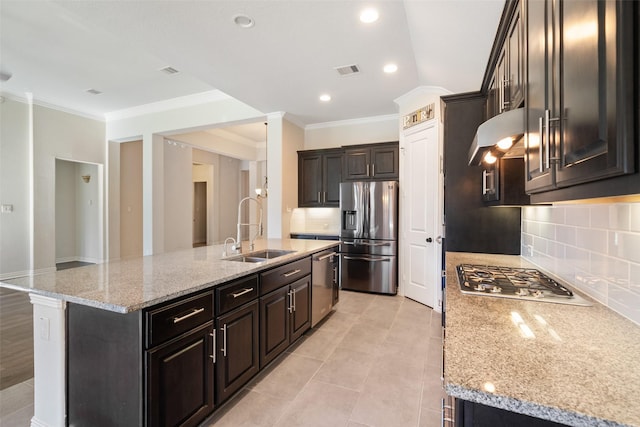 kitchen featuring stainless steel appliances, sink, a kitchen island with sink, and light stone counters