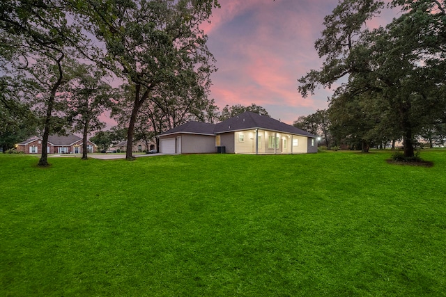 view of yard with a garage and driveway