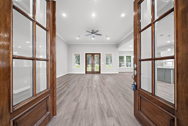 unfurnished living room featuring french doors, crown molding, light wood finished floors, recessed lighting, and baseboards