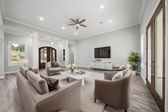 living room with light wood-style flooring, baseboards, ornamental molding, french doors, and decorative columns