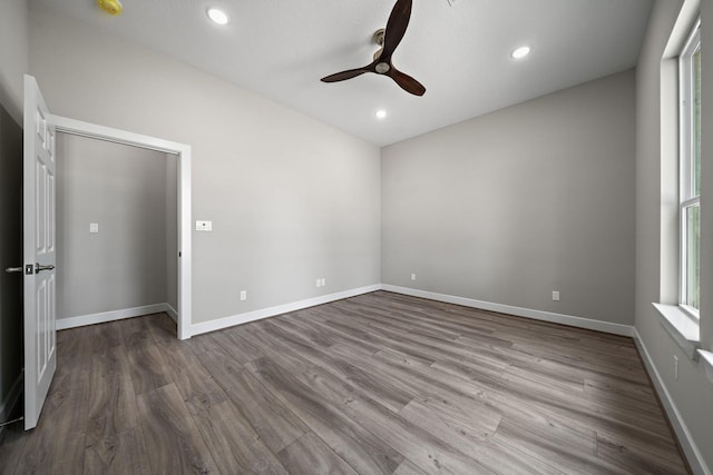 unfurnished room with ceiling fan, recessed lighting, wood finished floors, and baseboards