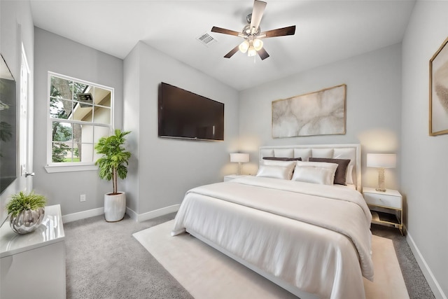 bedroom featuring a ceiling fan, light colored carpet, visible vents, and baseboards