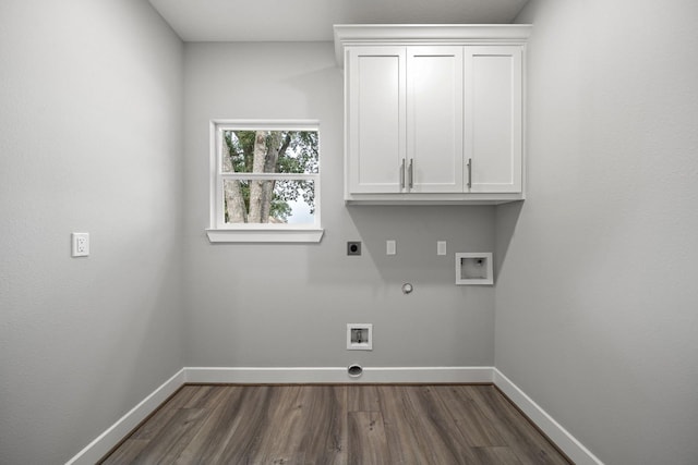 laundry area featuring cabinet space, baseboards, dark wood-style floors, hookup for a gas dryer, and electric dryer hookup