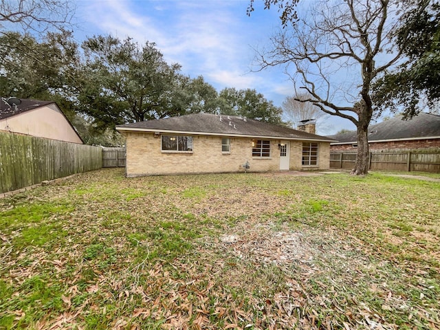 rear view of property with a lawn