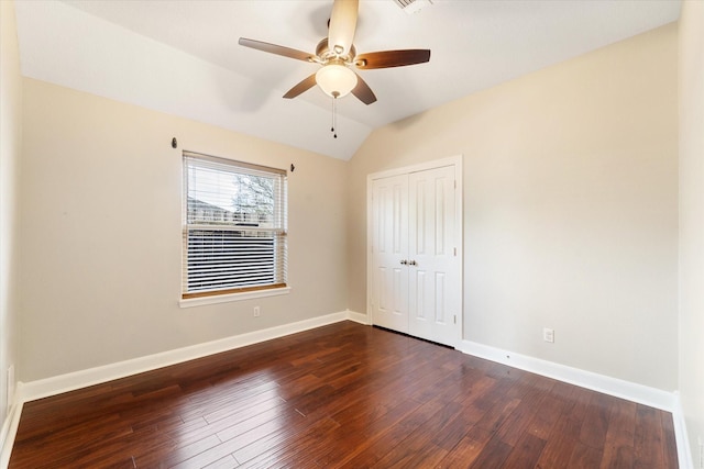 empty room with vaulted ceiling, dark wood-type flooring, and ceiling fan