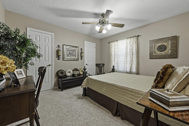 bedroom with ceiling fan, light carpet, and a textured ceiling