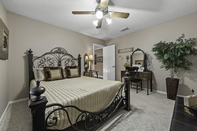 carpeted bedroom featuring ceiling fan and a textured ceiling