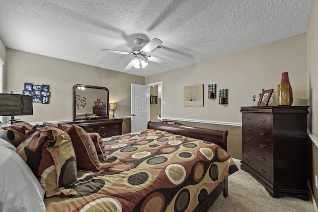 carpeted bedroom with ceiling fan and a textured ceiling